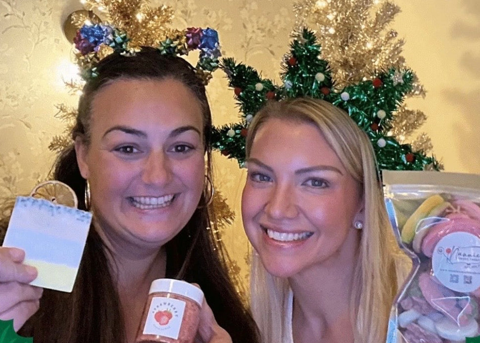 Two women with Christmas-themed photo frame holding products.